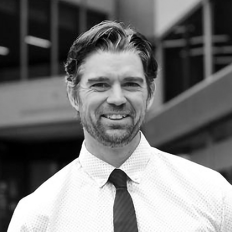 Headshot of Patrick Madden in black & white.